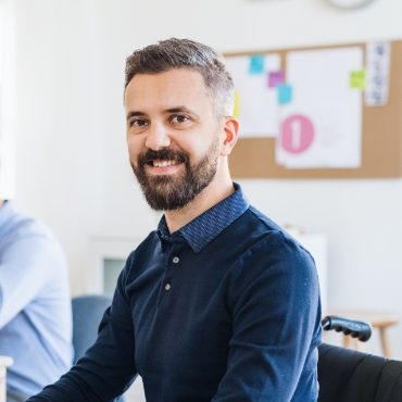 demo-attachment-88-young-businessman-in-wheelchair-with-colleagues-EWTN4AC